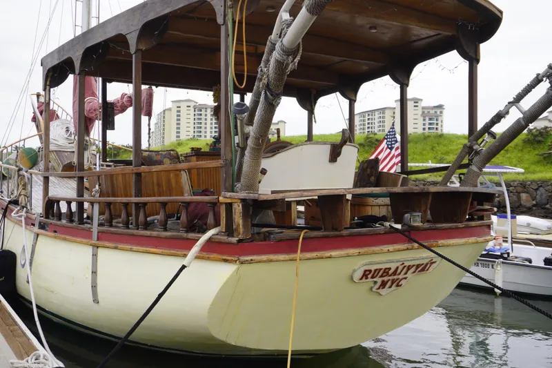 Slide: The Image of Vintage 1976 Manila Shipbuilders sailboat docked, featuring wooden deck and American flag. - 59