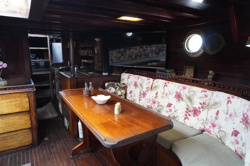Slide: The Image of Interior of a 1976 Manila Shipbuilders sailboat with floral seating and wooden furnishings. - 6