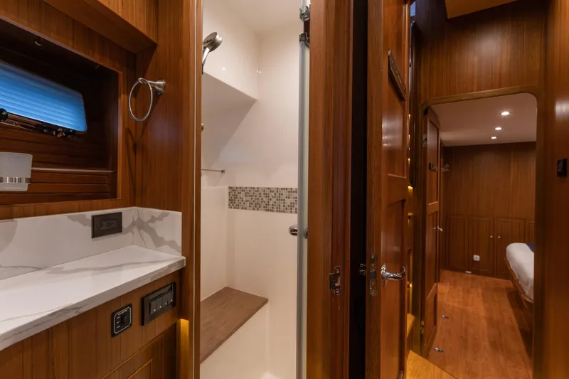Slide: The Image of Luxurious 2021 North Pacific 49 Pilothouse interior with wood finish and modern bathroom. - 13