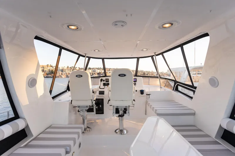 Slide: The Image of Interior of 2021 North Pacific 49 Pilothouse with modern seating and panoramic windows. - 15