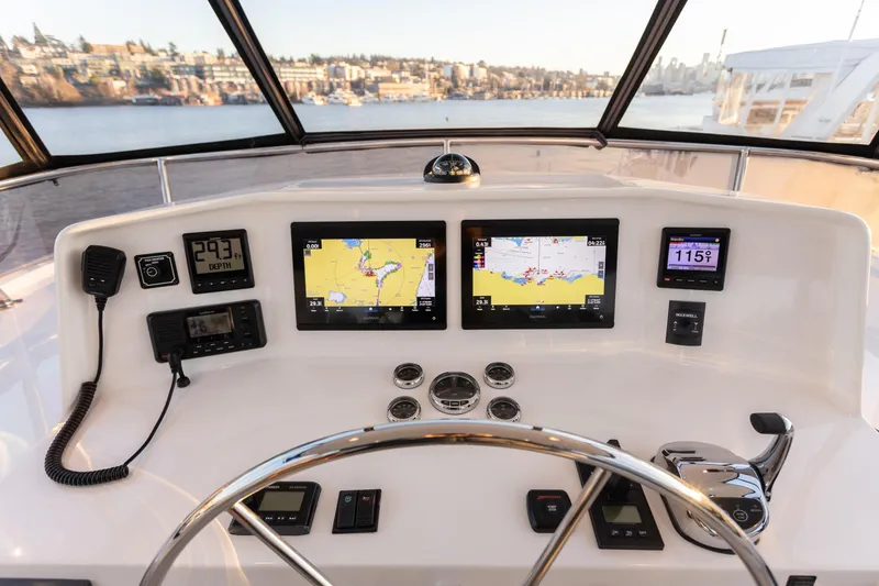 Slide: The Image of Pilothouse of 2021 North Pacific 49, featuring navigation screens and controls with scenic water view. - 17