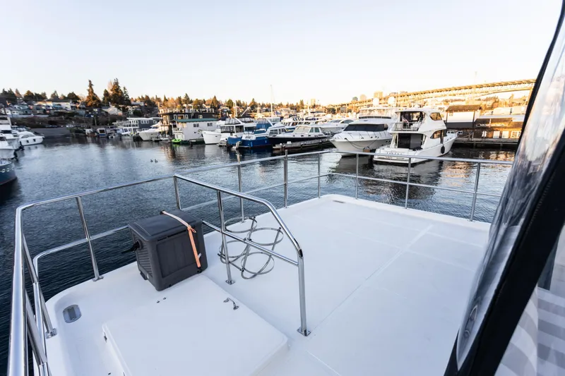 Slide: The Image of 2021 North Pacific 49 Pilothouse yacht docked in a marina with scenic waterfront views. - 18