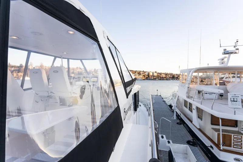 Slide: The Image of 2021 North Pacific 49 Pilothouse yacht docked, showcasing sleek design and spacious interior. - 19