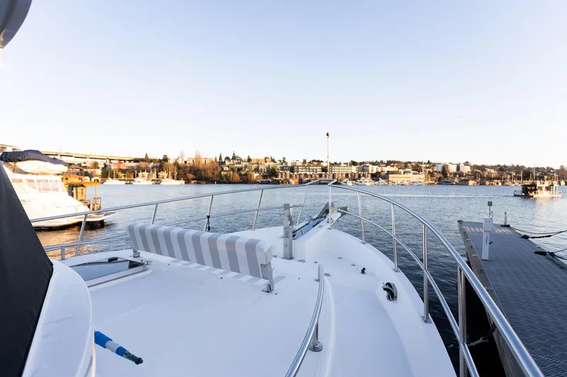 Slide: The Image of North Pacific 49 Pilothouse yacht, 2021 model, docked with scenic waterfront view. - 21