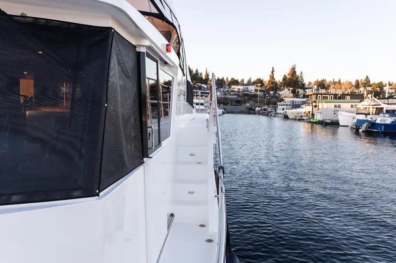 Slide: The Image of 2021 North Pacific 49 Pilothouse yacht docked by waterfront homes. - 24