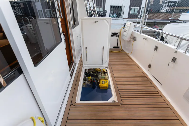 Slide: The Image of North Pacific 49 Pilothouse 2021 yacht deck with open hatch revealing engine compartment. - 28