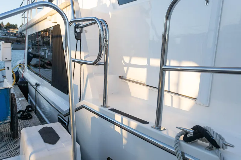Slide: The Image of 2021 North Pacific 49 Pilothouse yacht docked, showcasing sleek design and stainless steel railings. - 36