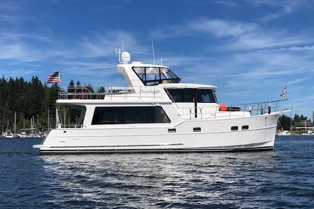 Slide: The Image of 2021 North Pacific 49 Pilothouse yacht on calm water, with clear blue sky. - 39