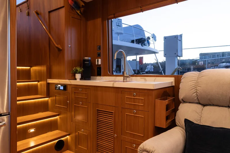 Slide: The Image of Luxurious interior of 2021 North Pacific 49 Pilothouse yacht with wooden cabinetry and modern amenities. - 4