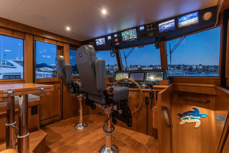 Slide: The Image of Pilothouse interior of 2021 North Pacific 49, featuring modern navigation equipment and wooden finishes. - 5