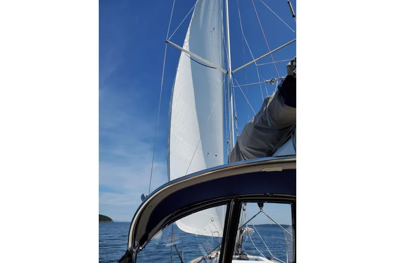 Slide: The Image of 2017 Jeanneau Sun Odyssey 349 sailboat with sails unfurled on a clear day. - 14