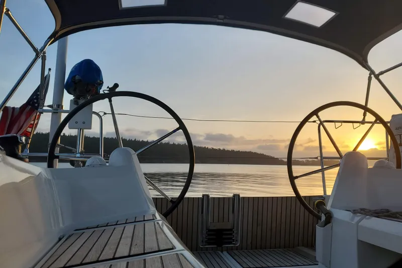 Slide: The Image of 2017 Jeanneau Sun Odyssey 349 sailboat cockpit at sunset on calm waters. - 17