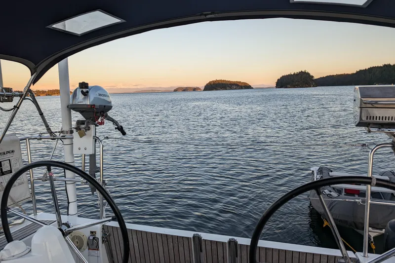 Slide: The Image of Cockpit view from 2017 Jeanneau Sun Odyssey 349 sailboat, overlooking serene waters and distant islands. - 27