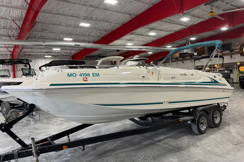 The Image of 1998 Sea Ray 240 Sundeck boat on trailer in indoor storage facility. - 1