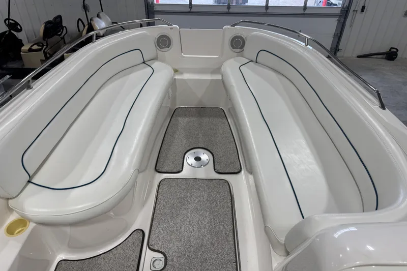 Slide: The Image of 1998 Sea Ray 240 Sundeck interior with white seating and carpeted floor. - 10
