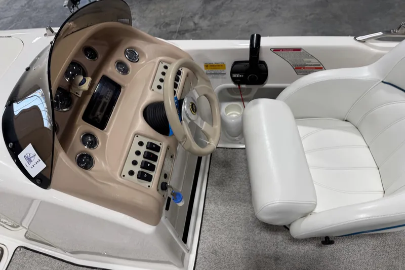 Slide: The Image of 1998 Sea Ray 240 Sundeck cockpit with steering wheel, gauges, and white captain's chair. - 8