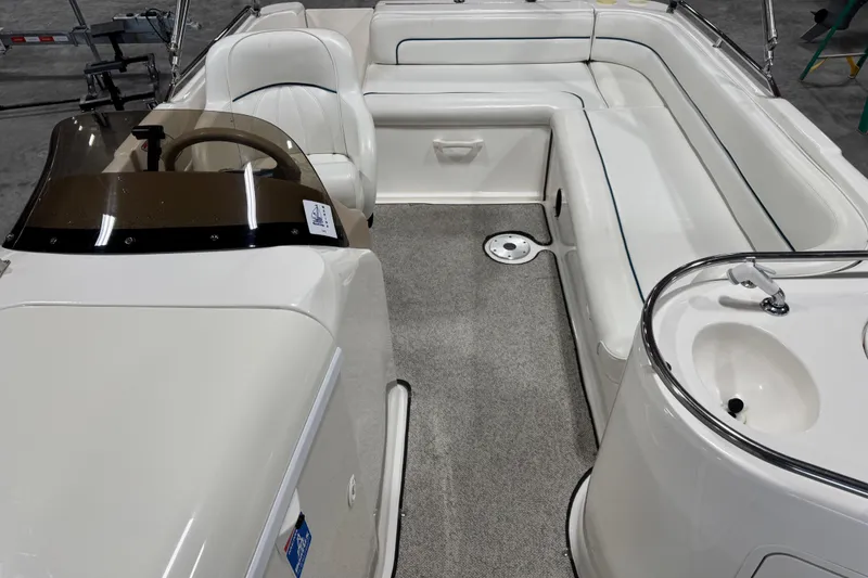 Slide: The Image of 1998 Sea Ray 240 Sundeck interior with seating and helm, showcasing luxury boat design. - 9