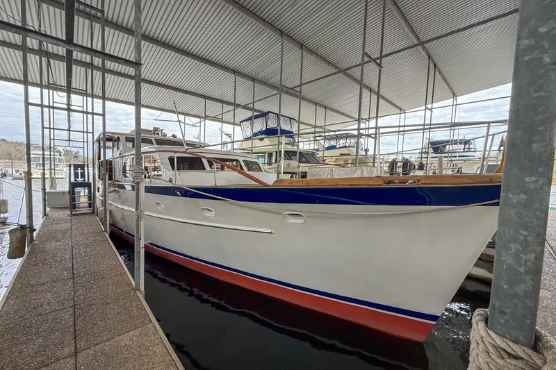 Slide: The Image of 1956 Burger Pilothouse yacht docked under a covered marina. - 10