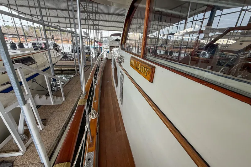 Slide: The Image of 1956 Burger Pilothouse yacht "Hi Lady" docked in a marina, showcasing wooden deck and classic design. - 12