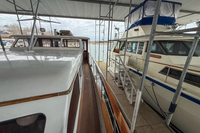 Slide: The Image of 1956 Burger Pilothouse yacht docked under a covered marina, showcasing classic design. - 13