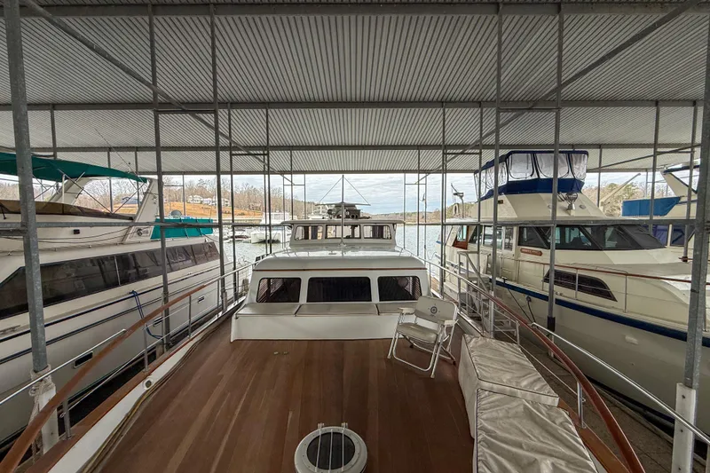 Slide: The Image of 1956 Burger Pilothouse yacht docked in a marina, surrounded by other boats. - 14