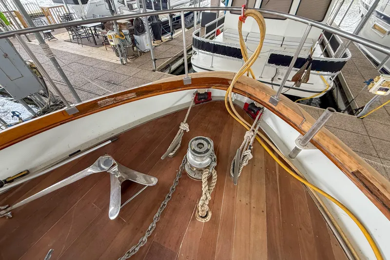Slide: The Image of 1956 Burger Pilothouse yacht deck with anchor and ropes in marina setting. - 15