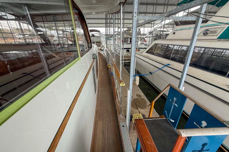 Slide: The Image of 1956 Burger Pilothouse yacht docked in a marina, showcasing sleek design and classic elegance. - 17