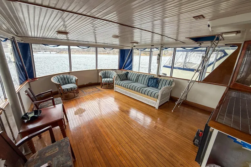 Slide: The Image of Interior of a 1956 Burger Pilothouse yacht with wooden floors and striped seating. - 18