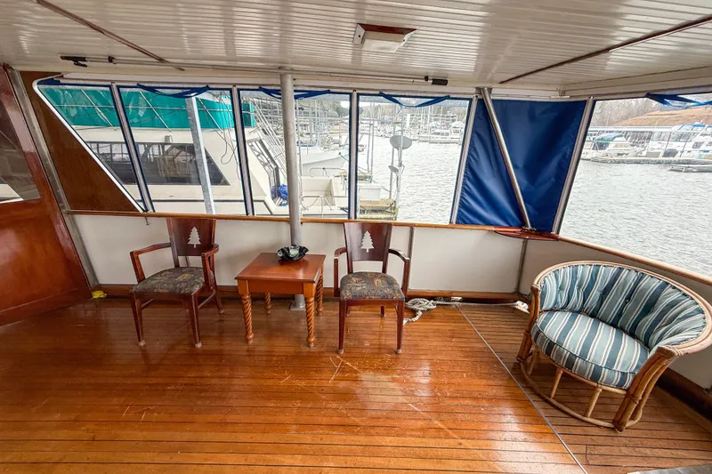 Slide: The Image of 1956 Burger Pilothouse interior with wooden flooring, chairs, and marina view. - 19