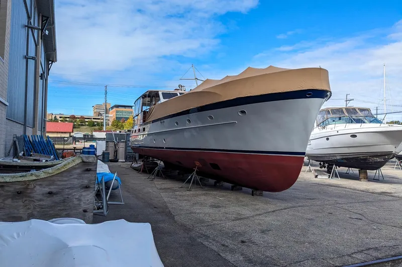 Slide: The Image of 1956 Burger Pilothouse yacht in a boatyard, covered and elevated for maintenance. - 2