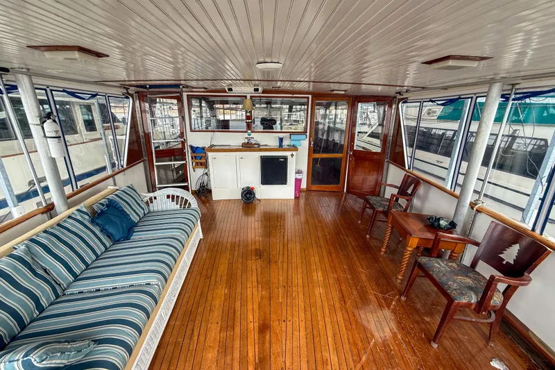 Slide: The Image of 1956 Burger Pilothouse interior with wooden flooring, striped sofa, and chairs. - 21