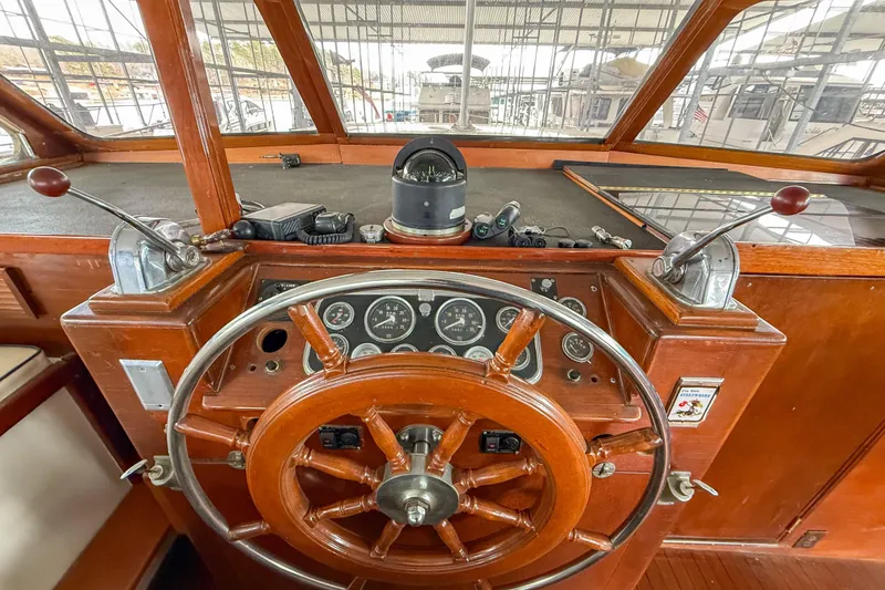Slide: The Image of 1956 Burger Pilothouse helm with wooden wheel and vintage navigation instruments. - 24