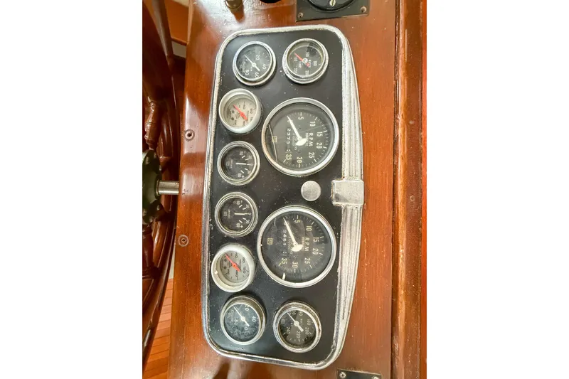 Slide: The Image of 1956 Burger Pilothouse dashboard with vintage gauges and wooden paneling. - 26