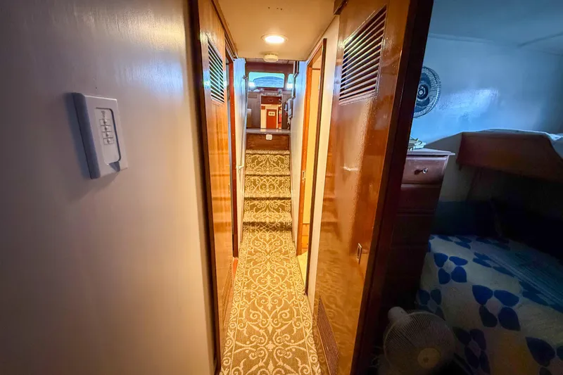 Slide: The Image of Interior hallway of a 1956 Burger Pilothouse yacht with wood paneling and carpeted stairs. - 32