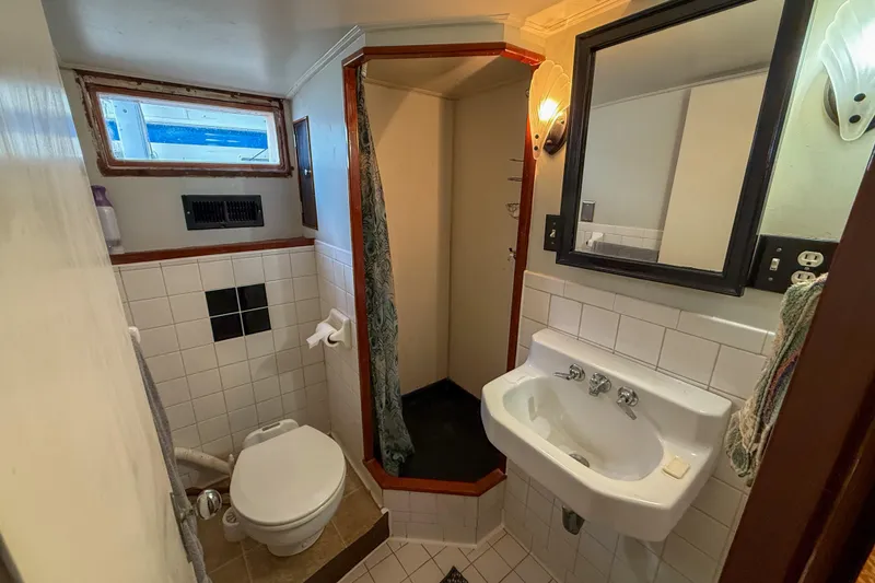 Slide: The Image of Compact bathroom in a 1956 Burger Pilothouse boat with shower, sink, and toilet. - 33