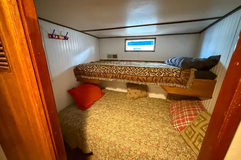 Slide: The Image of Cozy 1956 Burger Pilothouse cabin with bunk beds and patterned bedding. - 34
