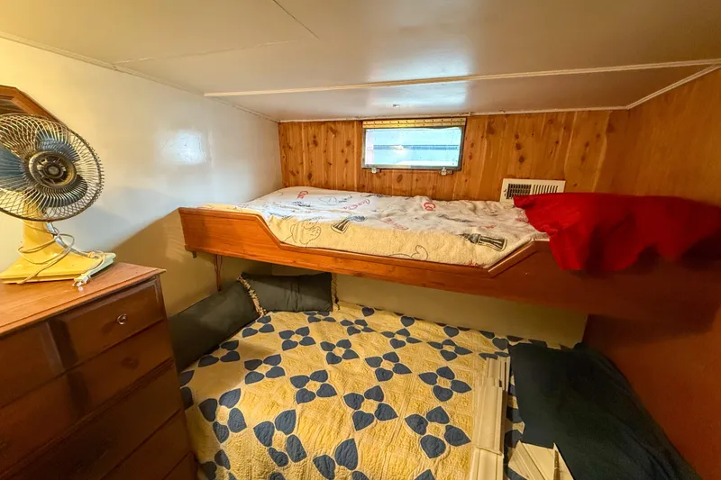Slide: The Image of 1956 Burger Pilothouse cabin with bunk beds, wooden paneling, and vintage fan. - 35