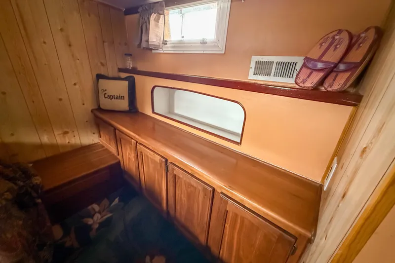 Slide: The Image of 1956 Burger Pilothouse interior with wooden cabinetry, window, and "The Captain" pillow. - 39