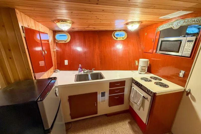 Slide: The Image of 1956 Burger Pilothouse kitchen with wood paneling, compact appliances, and nautical decor. - 41