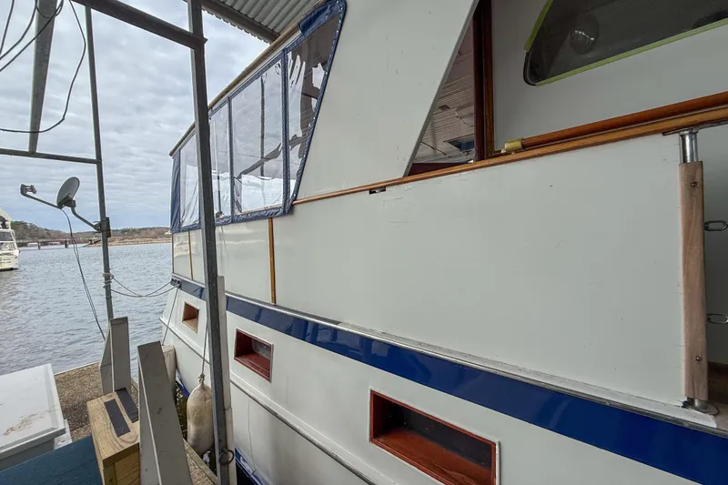 Slide: The Image of 1956 Burger Pilothouse boat docked, featuring white exterior with blue accents. - 8