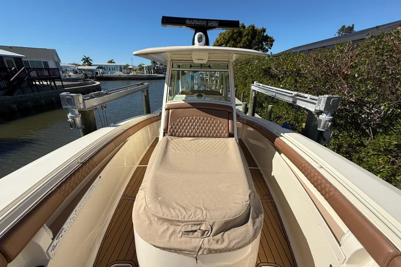 Slide: The Image of 2018 Scout 350 LXF boat docked, featuring cushioned seating and Garmin radar. - 12