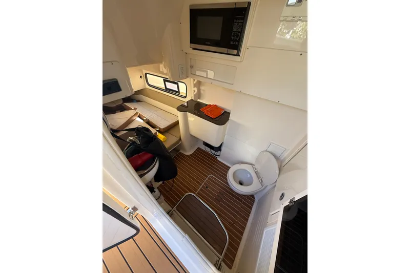 Slide: The Image of 2018 Scout 350 LXF cabin interior with wood flooring, toilet, and microwave. - 15