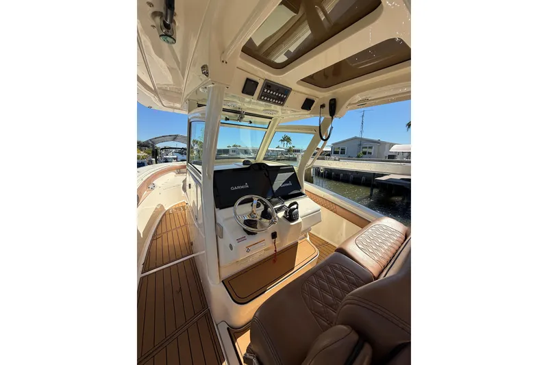 Slide: The Image of 2018 Scout 350 LXF boat interior with Garmin navigation, luxurious seating, and wood flooring. - 8