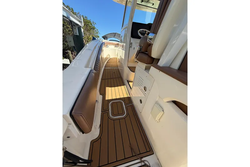 Slide: The Image of 2018 Scout 350 LXF boat interior with teak flooring and cushioned seating. - 9