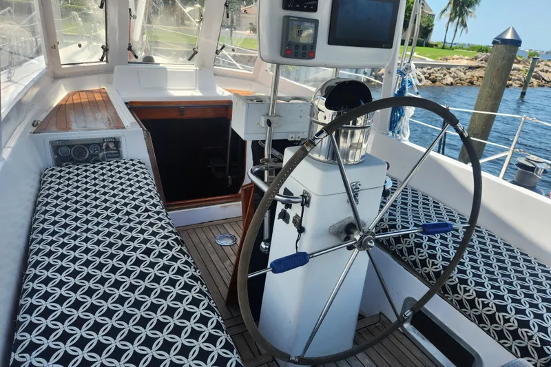 Slide: The Image of Cockpit of 1982 Tayana Center Cockpit Cutter Ketch with patterned seating and steering wheel. - 10
