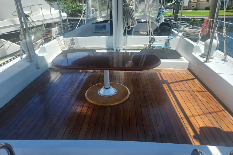 Slide: The Image of 1982 Tayana Center Cockpit Cutter Ketch with polished wooden deck and table. - 19