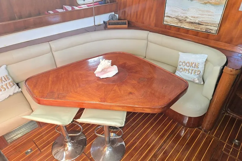 Slide: The Image of Cozy dining area in 1982 Tayana Center Cockpit Cutter Ketch with wooden table and cushioned seating. - 2