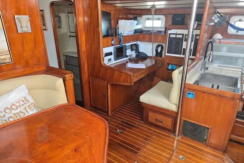 Slide: The Image of 1982 Tayana Center Cockpit Cutter Ketch interior with wood finish, navigation station, and galley. - 28