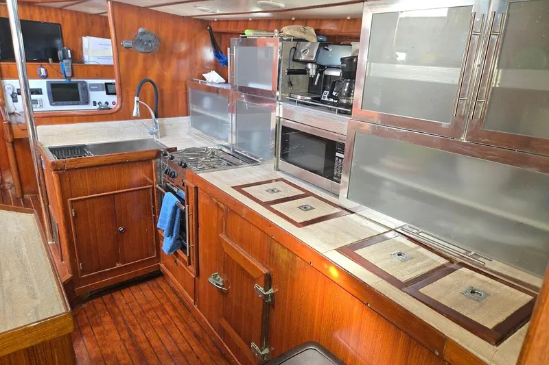 Slide: The Image of 1982 Tayana Center Cockpit Cutter Ketch galley with wood cabinetry and modern appliances. - 33