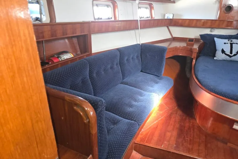 Slide: The Image of Interior of 1982 Tayana Center Cockpit Cutter Ketch with blue seating and wooden accents. - 39